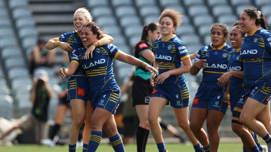 A group of women's rugby league players celebrate a win