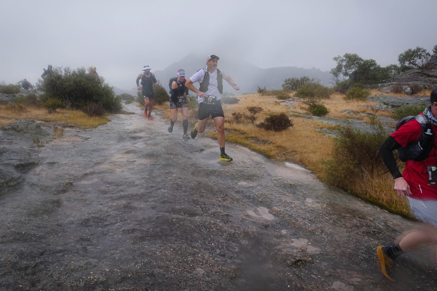runners on the grampians rocks in a heavy storm