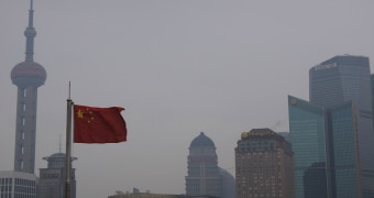 A Chinese flag flying above the skyline of a Chinese city