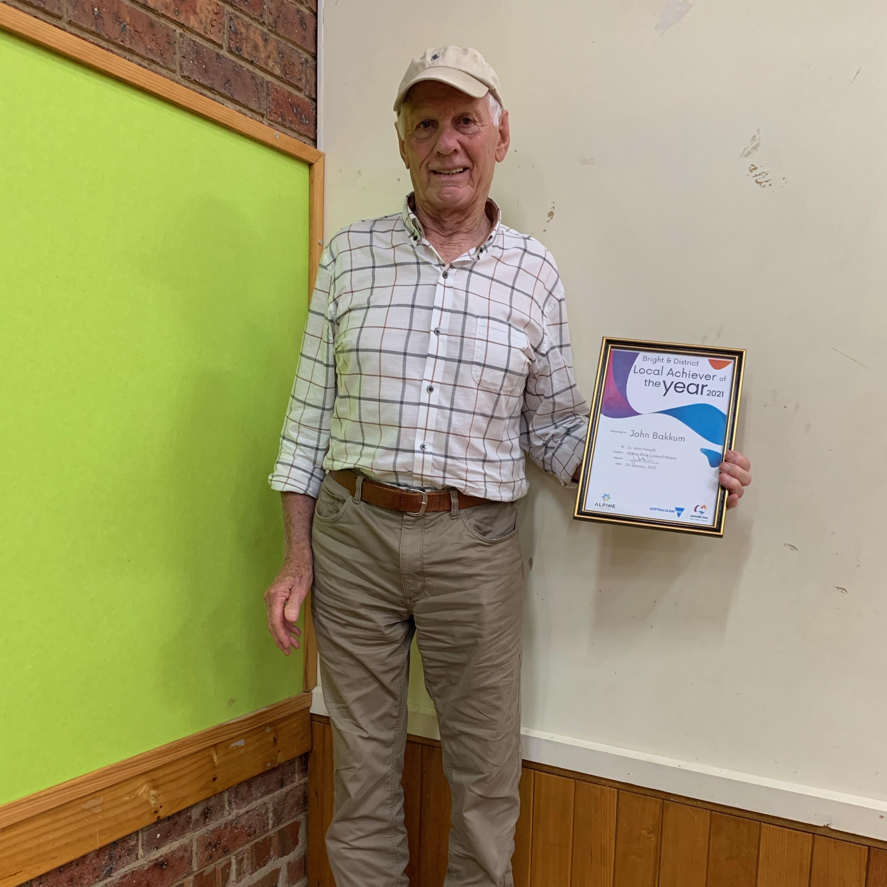 A man standing showing a certificate in his hand