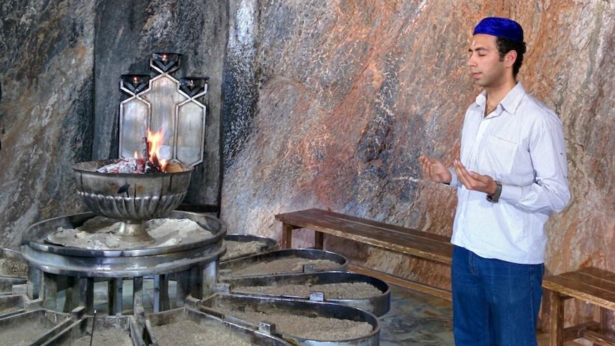 Farhad Malegam praying near fire.