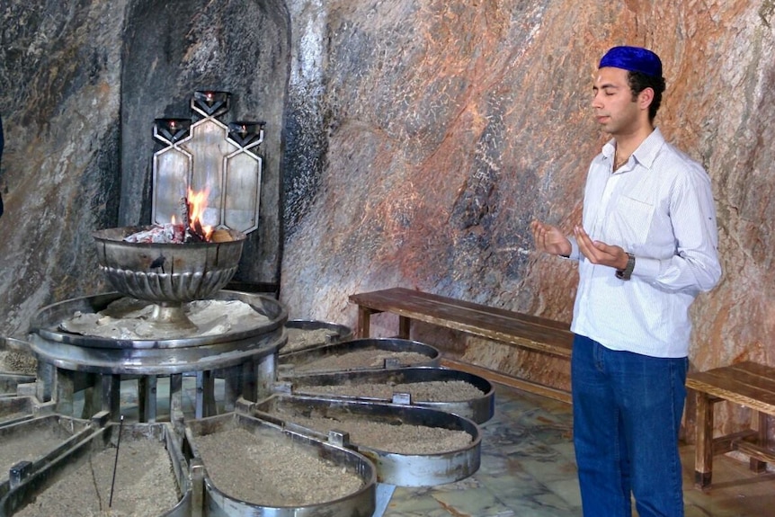 Farhad Malegam praying near fire.