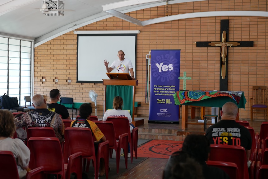 A man speaks into a microphone at Saint Teresa's Church for the Come Together For Yes rally