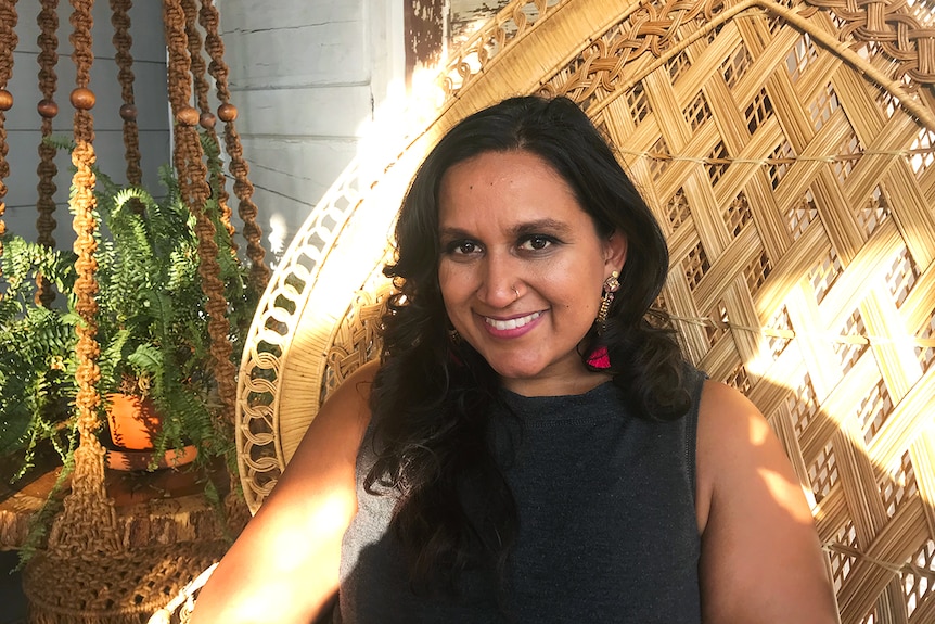 Philosophy academic Dr Serene J. Khader sitting in wicker chair.