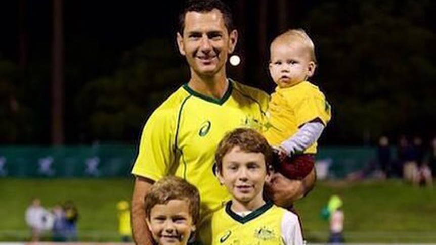 Australian hockey player Jamie Dwyer stands with his two sons, Julian and Taj, and holds his baby girl Zara