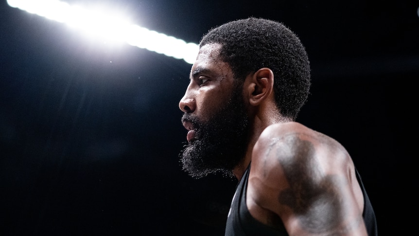 Kyrie Irving on a basketball court under bright lights.