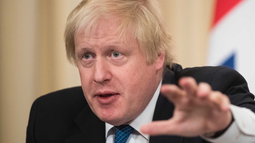 Boris Johnson speaks and gestures with his hand.