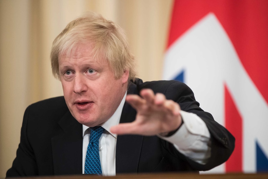 Boris Johnson speaks and gestures with his hand.