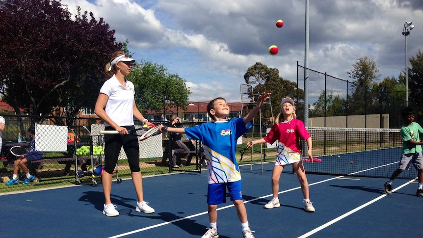 Alicia Molik teaching Ethan Prendergast and Annabelle Snow a serving technique in Canberra.