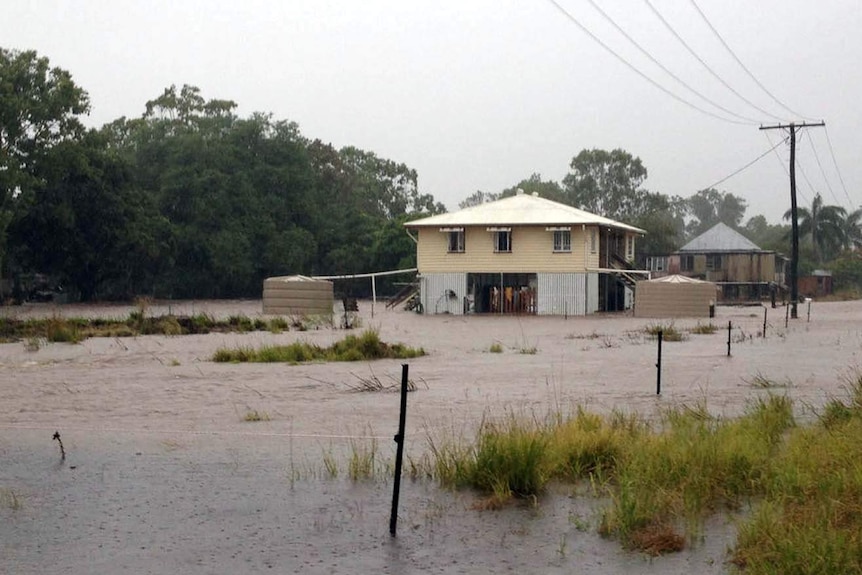 Floodwaters surround a house in Kabra