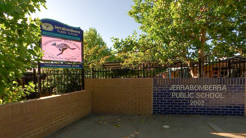 A sign on a brick wall saying Jerrabomberra Public School. 