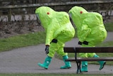 British army personnel wearing bright green protective hazmat suits