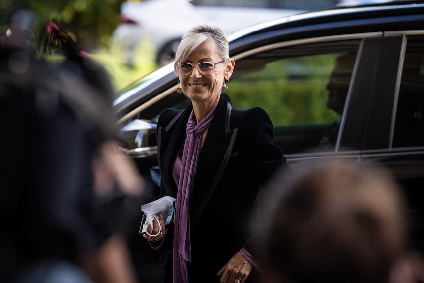 Elise Archer smiles as she steps out of a car.