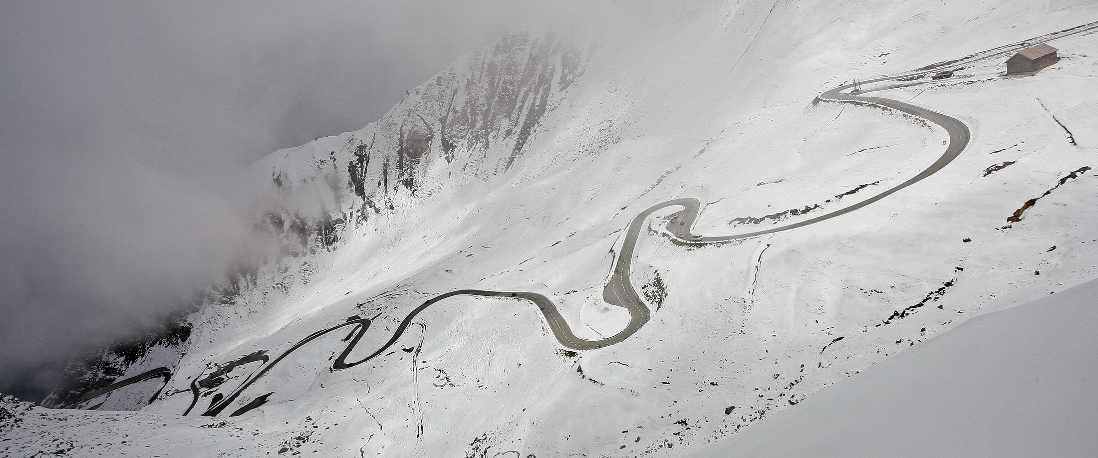 Una montaña nevada con un camino sinuoso.