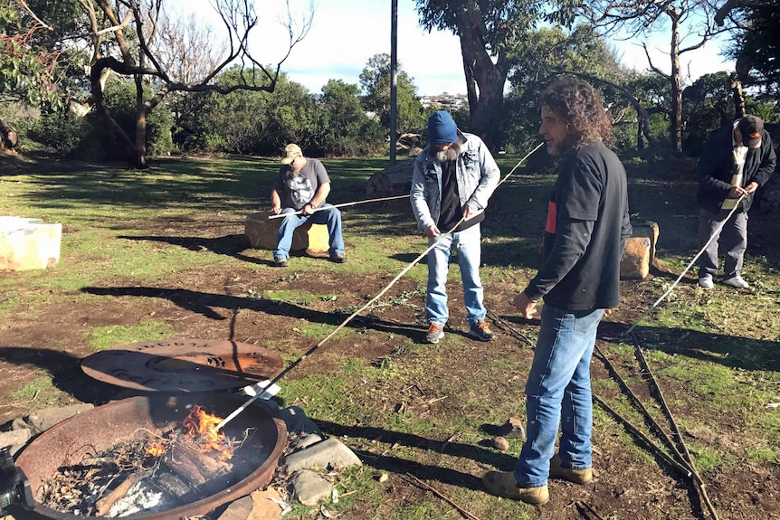 Men makes Aboriginal spears at a workshop.