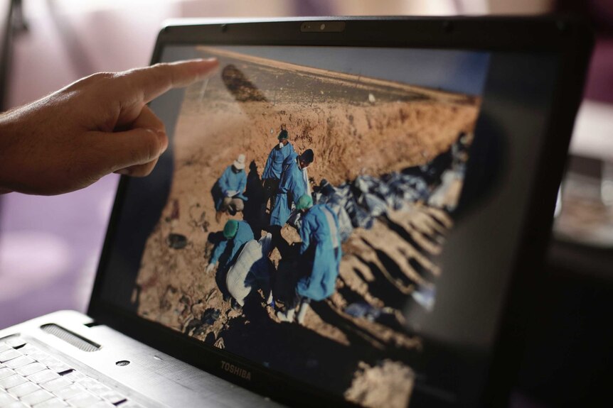 Sirwan Jalal, Director of Mass Graves for the Kurdish Regional Government, points to an image of the site of a mass grave.