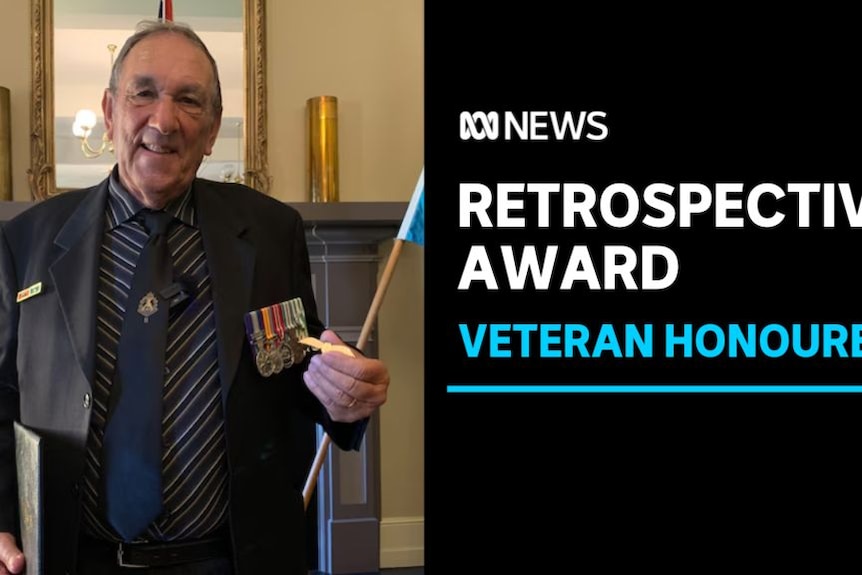 Retrospective Award, Veteran Honoured: A man wearing service medals holds a flag.