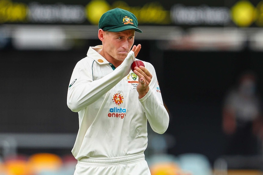 Australian fielder Marnus Labuschagne uses his sleeve to shine a cricket ball during a Test at the Gabba.