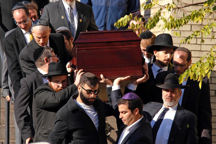 Jewish male pallbearers carrying the coffin of one of the victims of the Pittsburgh synagogue massacre.