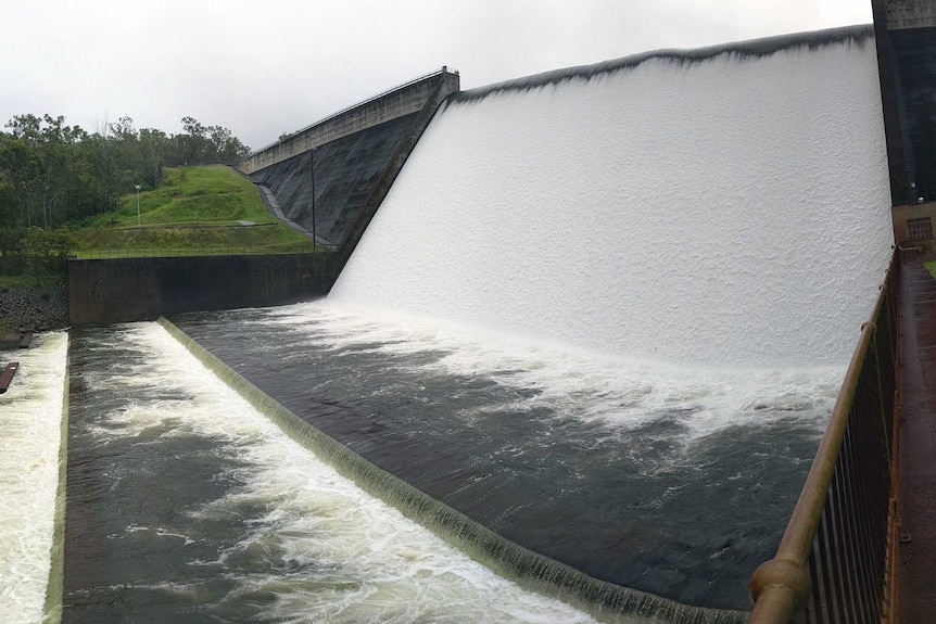 Water flows over the Tinaroo Dam spillway into the Barron River