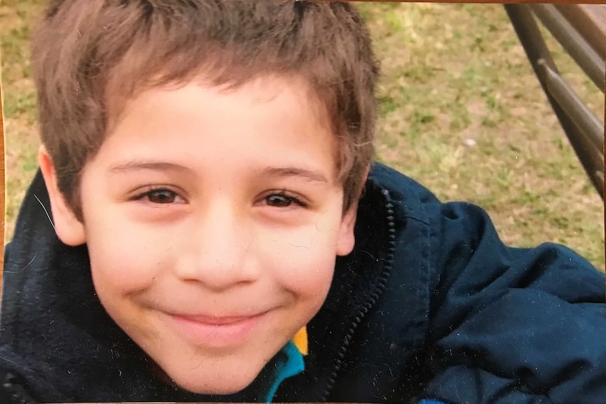 A home photograph of Korra smiling for the camera, aged six.