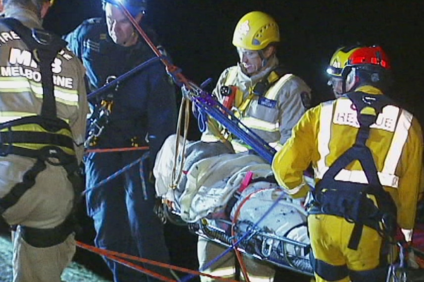 Injured woman on stretcher after slipping down 70m cliff