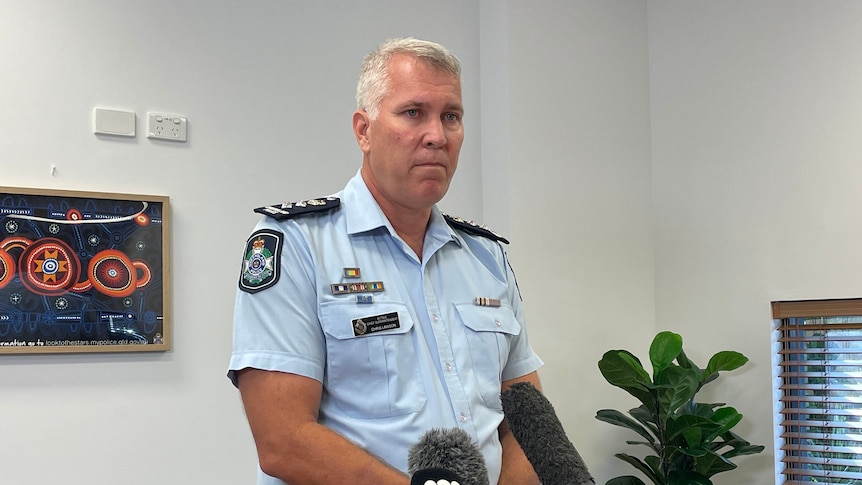 an acting chief superintendent holding a press conference in an office
