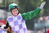 Michelle Payne waves to the crowd as she returns to scale on Prince Of Penzance after winning the Melbourne Cup.