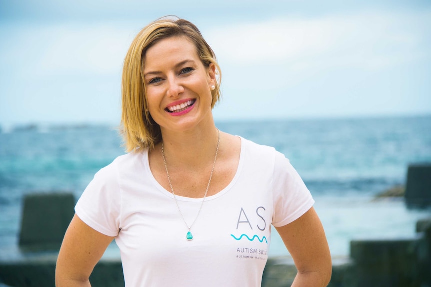 Erika Gleeson wearing a white t-shirt and smiling with bright pink lipstick