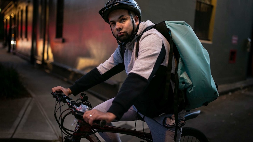 A man wearing a helmet sits on a bicycle.