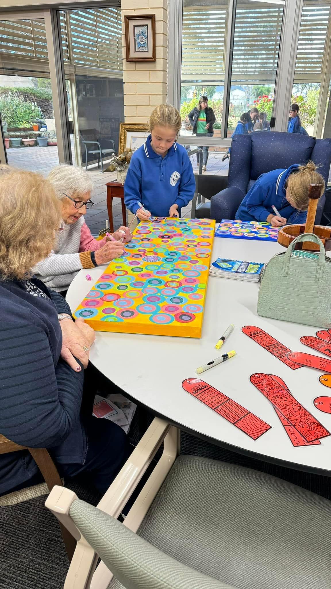 Children with elderly people working around a table on circle objects