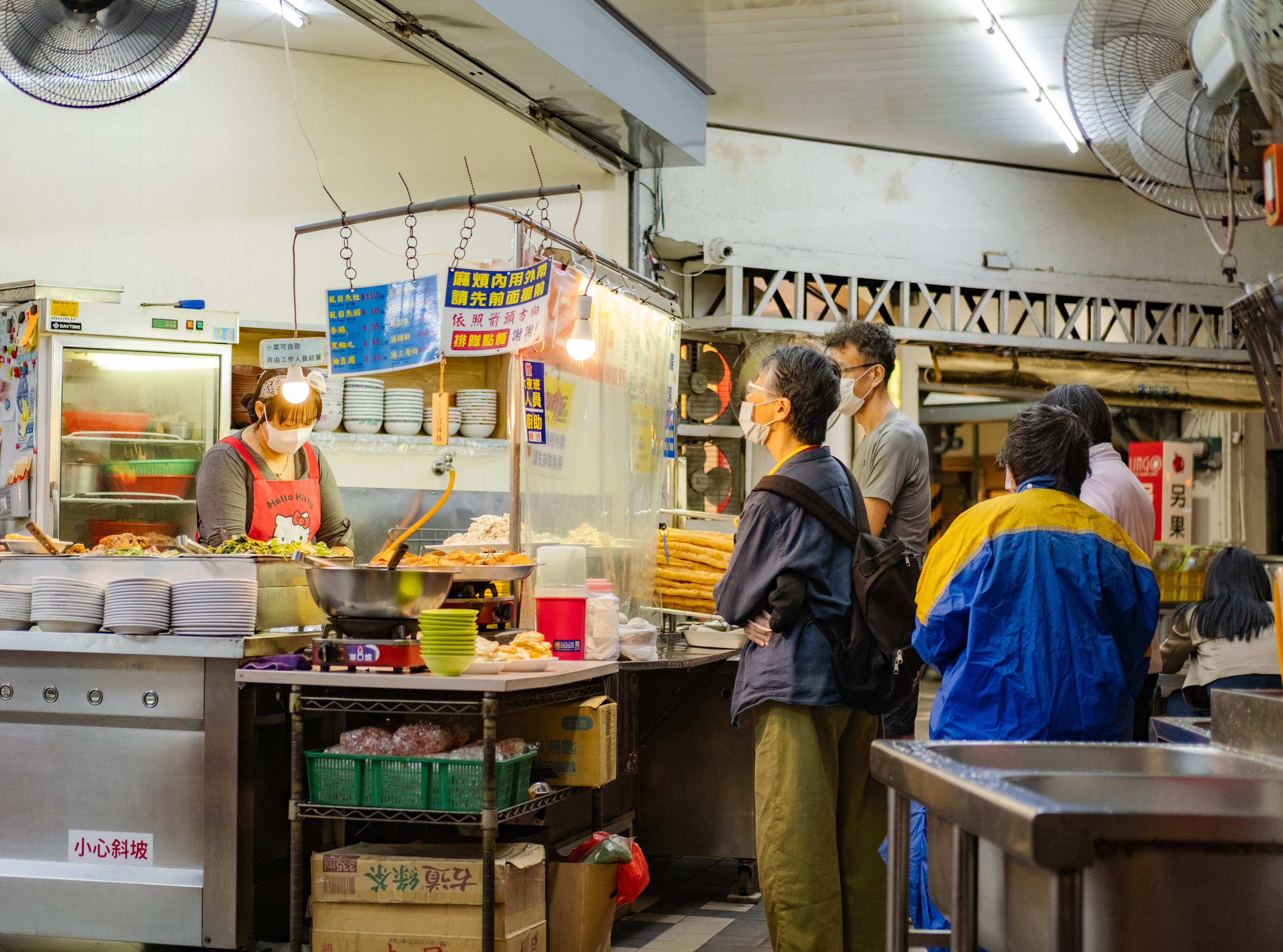Los clientes hacen fila en el mostrador de una tienda de comestibles.