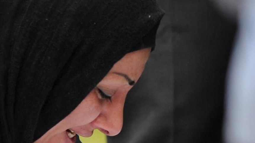 A mourner grieves at the funeral of one of the Christmas Island boat tragedy victims