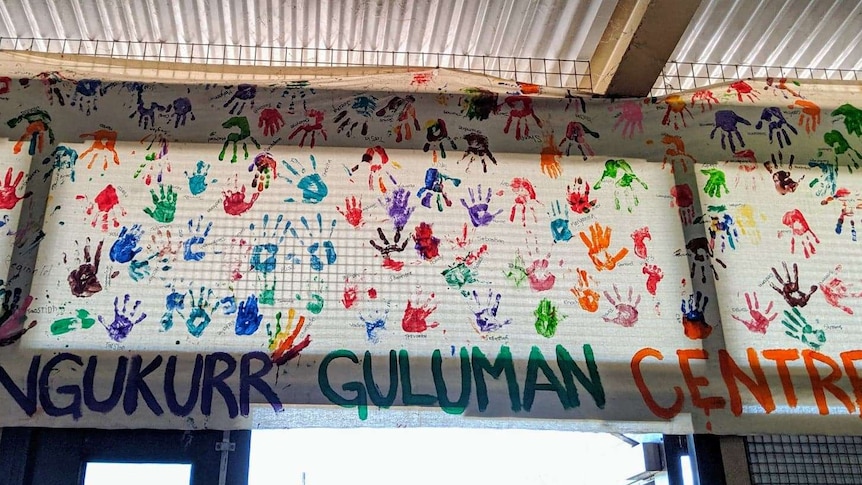 children's hand prints plastered on canvas above door.