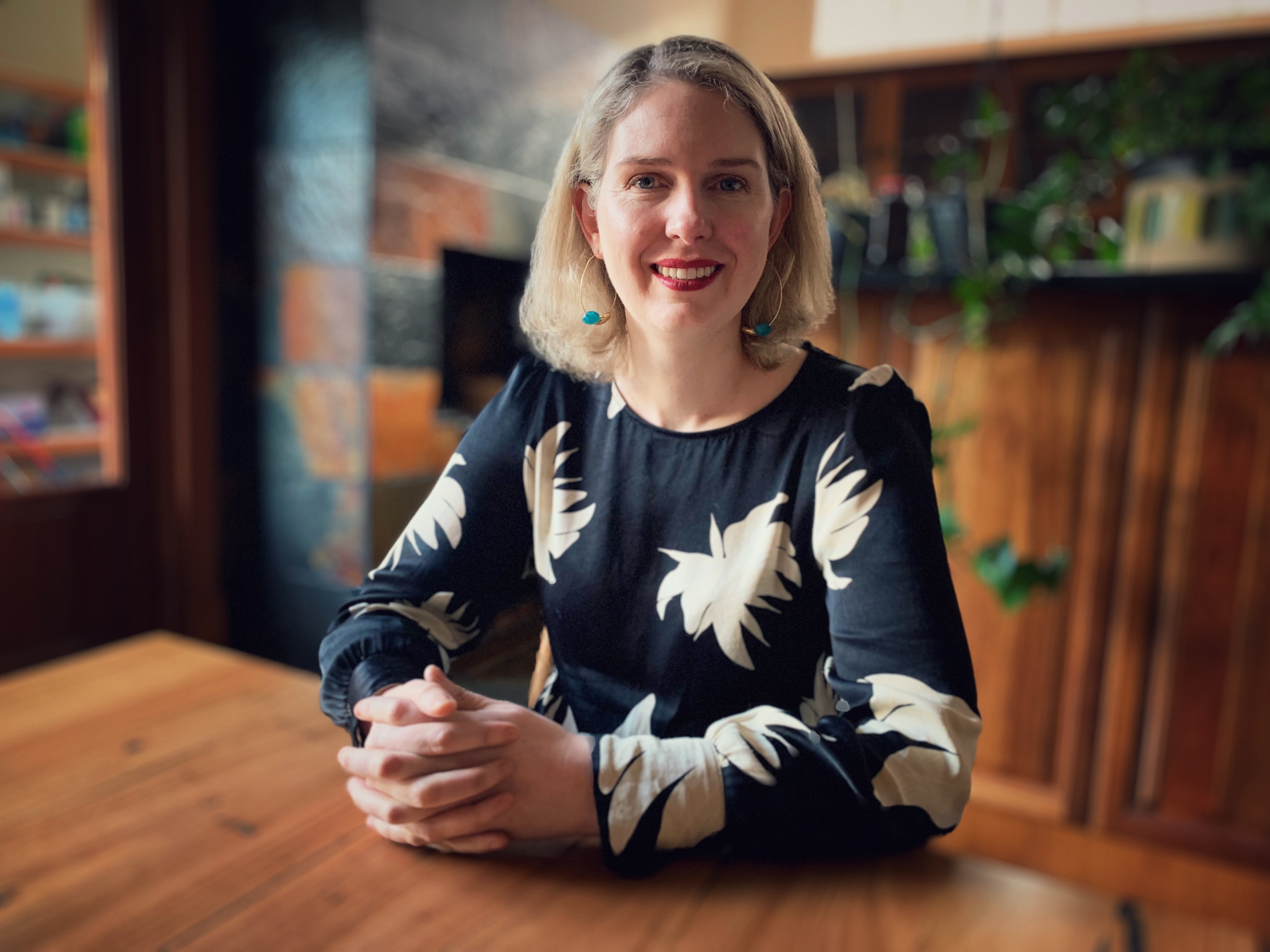 A blonde woman sitting at a kitchen table