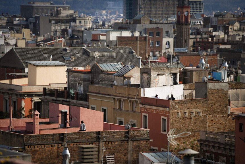 People looking for sunshine on their rooftops in Spain.