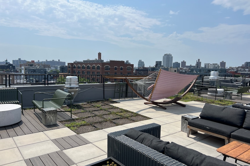 a rooftop with comfy lounge and a city view