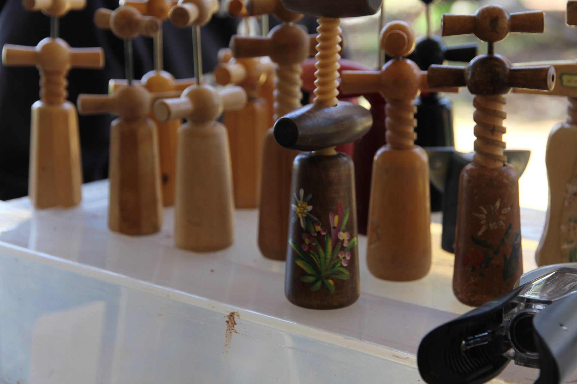 Wooden corcksrews standing up on a table.