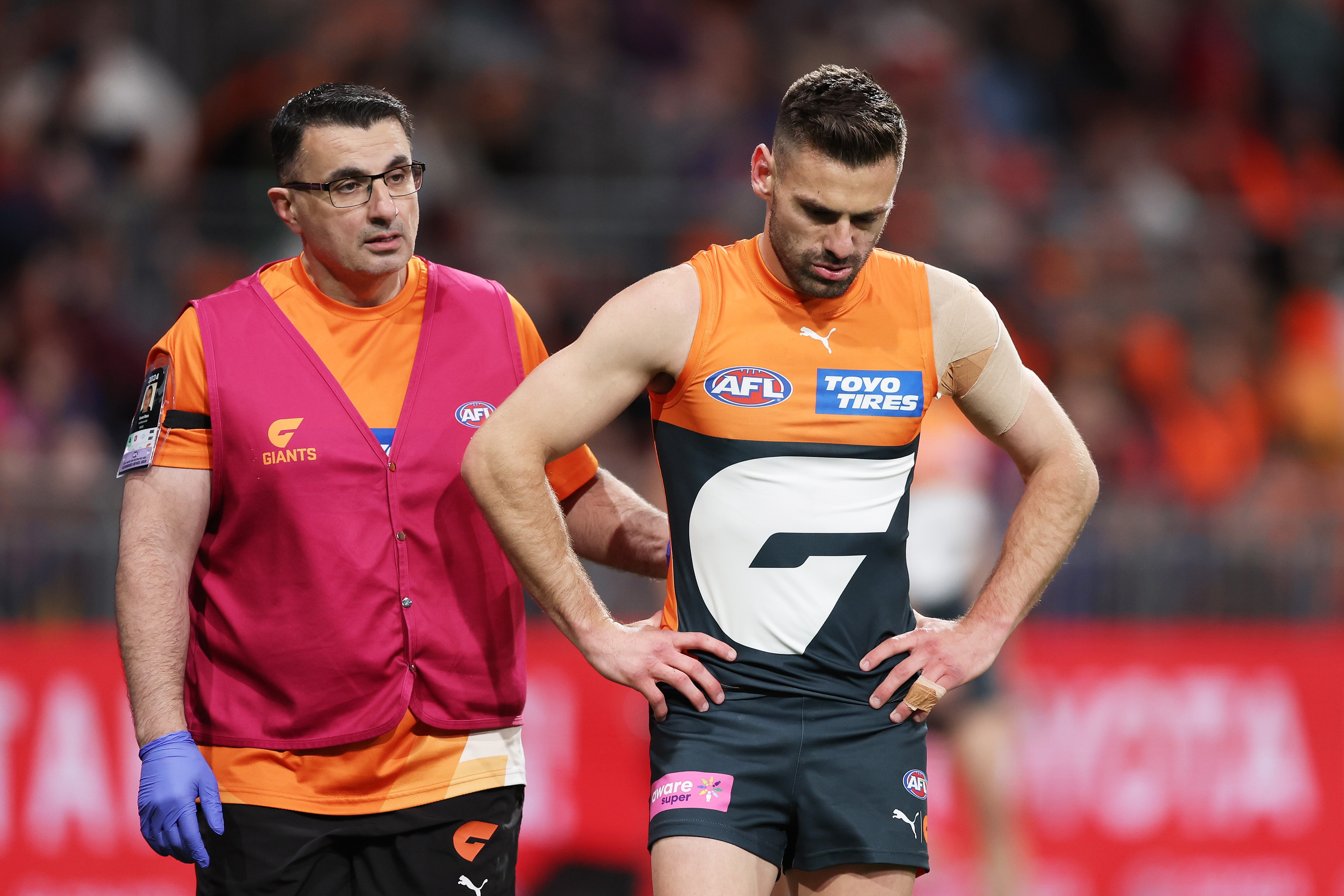 Stephen Coniglio accompanied by a Giants trainer