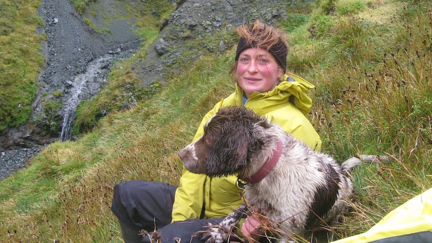 Rabbit hunter Nancye Williams takes a break with her dog Katie during pest eradication on Macquarie Island in 2012.