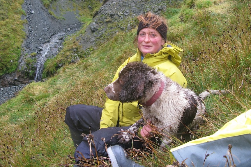 Rabbit hunter Nancye Williams takes a break with her dog Katie during pest eradication on Macquarie Island in 2012.