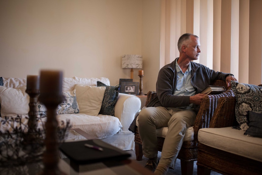 Pastor Jaco Classen sits by the window in his Kalgoorlie home.