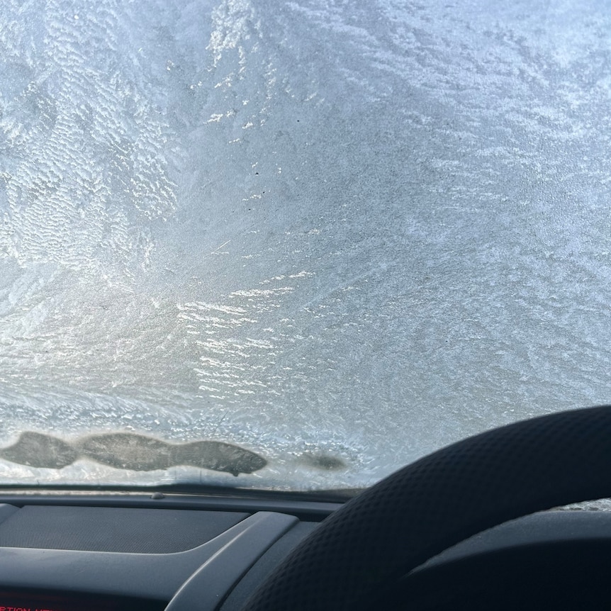 image from inside car from drivers seat of ice covering a windscreen