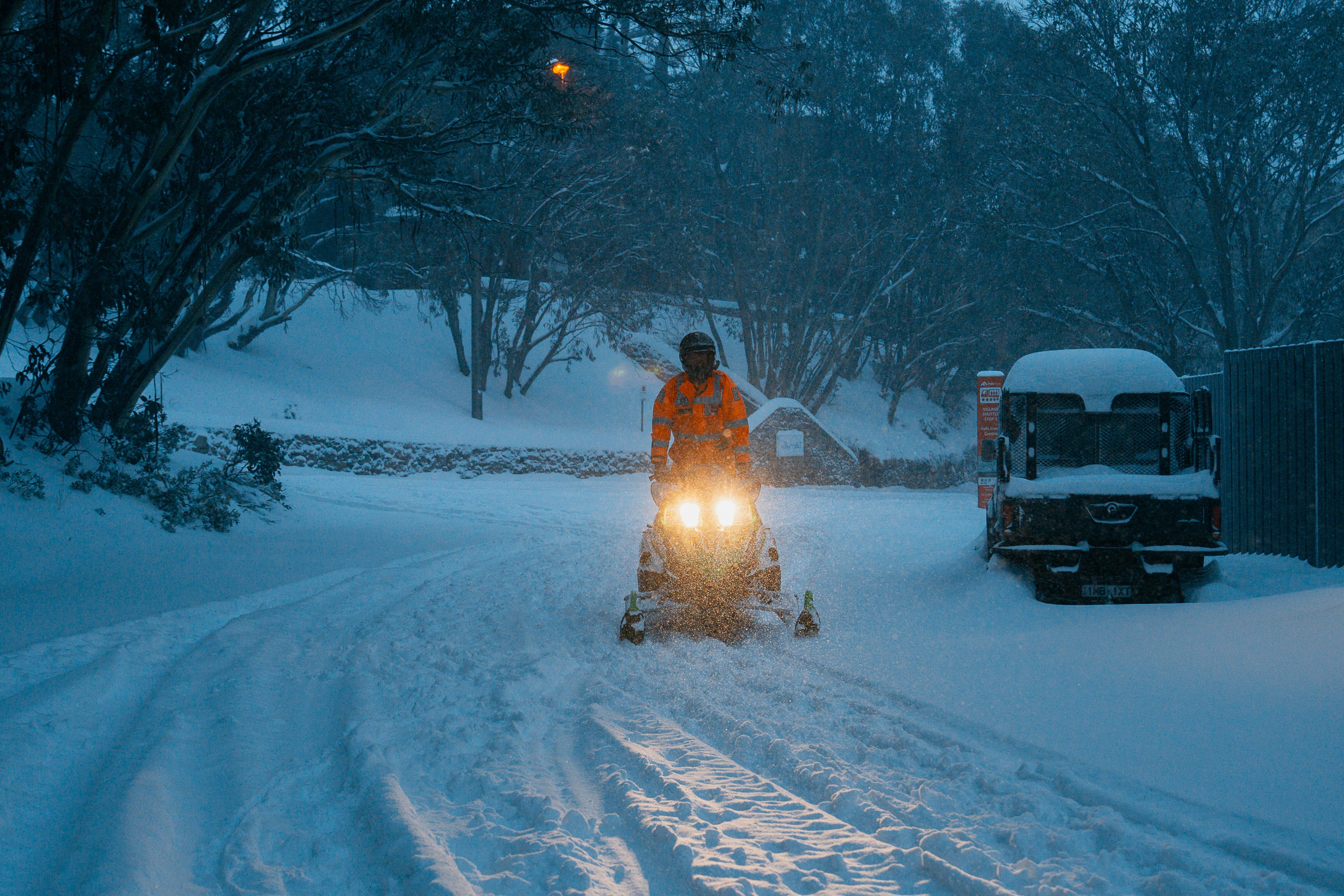 Persona que conduce nieve móvil a través de fuertes nieve.