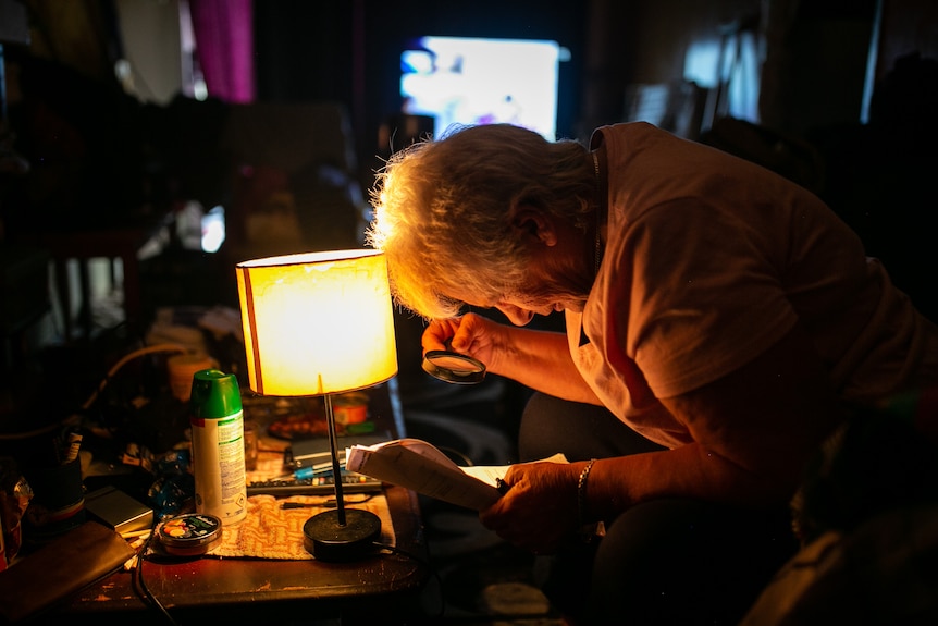 Cheryl looks at rental listings through a magnifying glass.