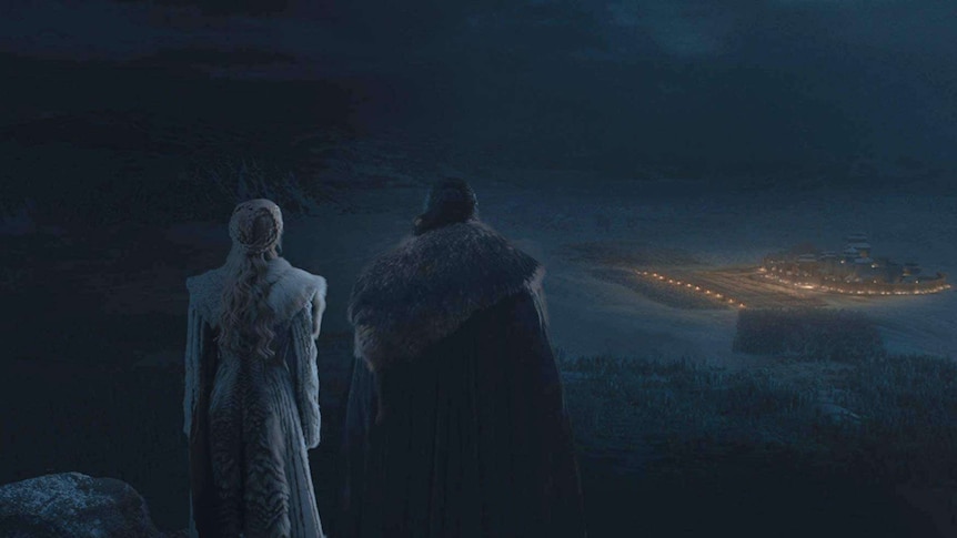 A still image from season eight of HBO's Game of Thrones with Jon Snow and Daenerys Targaryen looking over a battlefield.