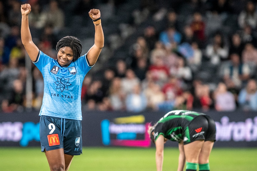 A Sydney FC A-League Women player raises her arms after winning the grand final against Western United.