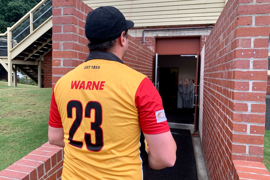 The back of a man wearing a shirt with 'Warne' and the number 23 on it.
