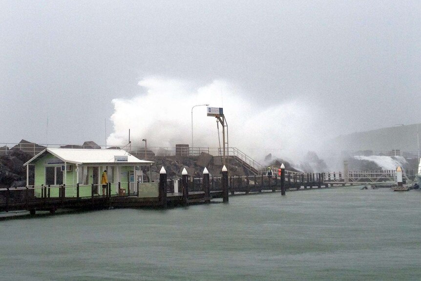 Waves smash over the breakwall at Coffs Harbour as ex-tropical cyclone Oswald moves south.