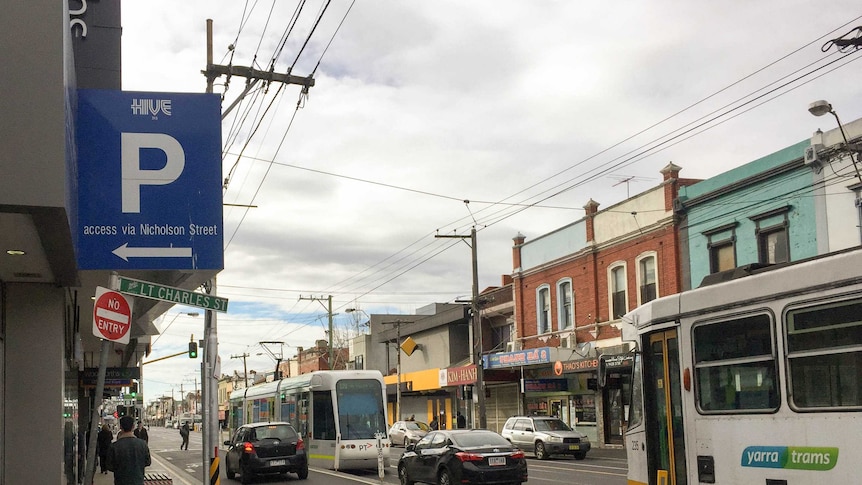 A street with trams and restaurants, sign to laneway reads "Lt Charles St".